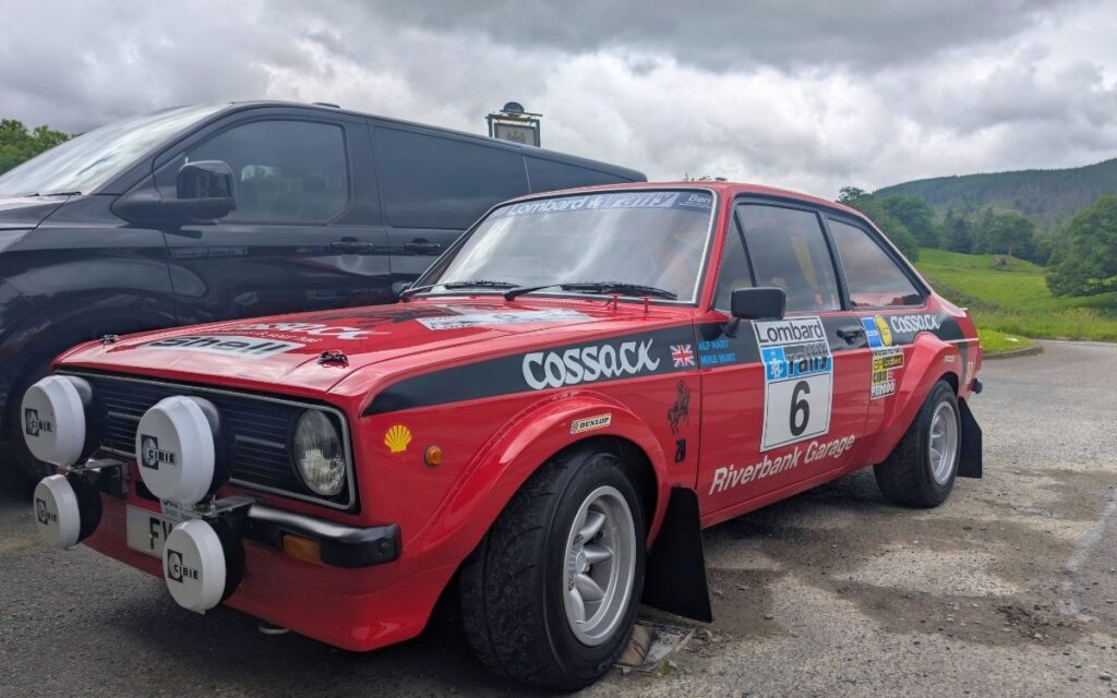Classic red Ford Escort Mk2 rally car featuring vintage Lombard RAC Rally and Cossack decals parked at the Kings Head, Thirlspot.