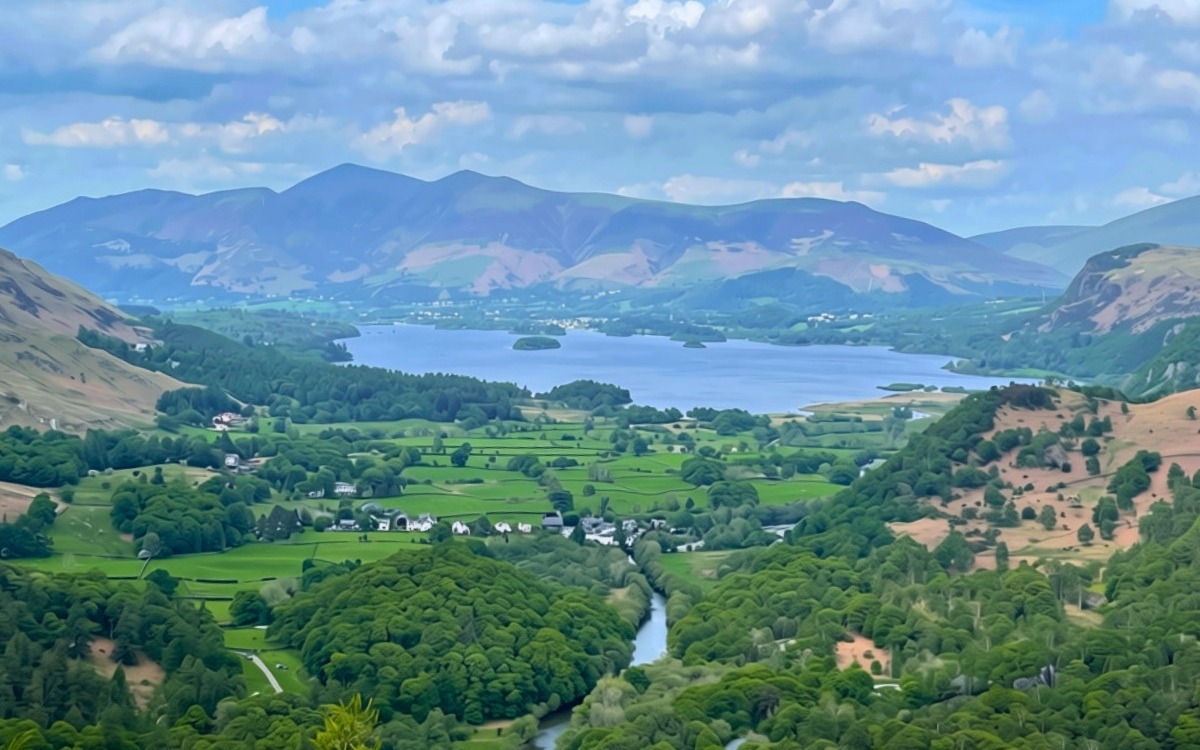 View looking north from the summit of Castle Crag across the Borrowdale valley, overlooking the calm blue waters of Derwent Water towards the high peak of Skiddaw.