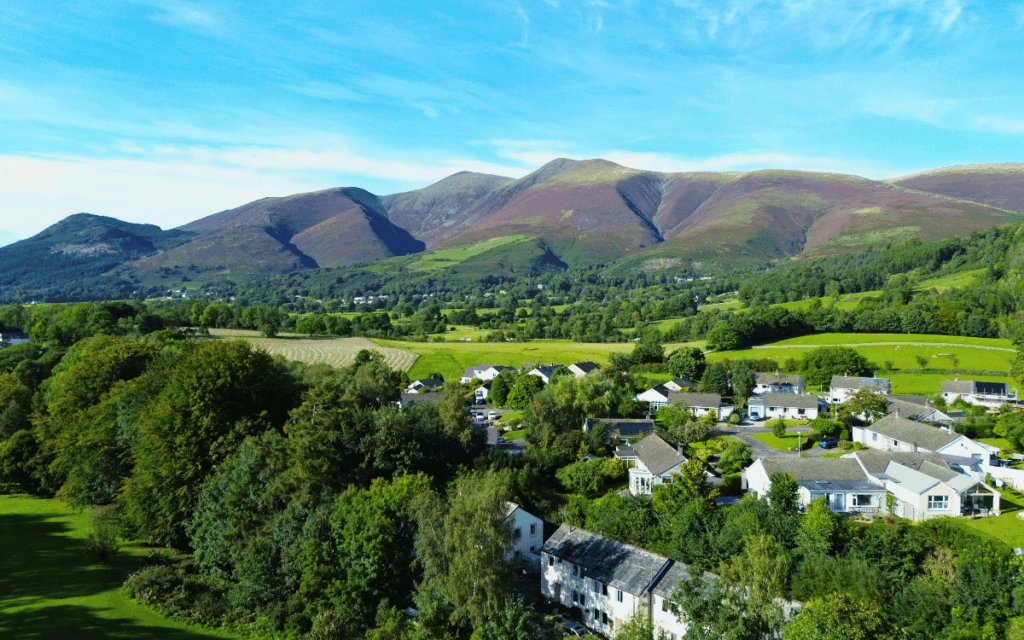 Drone photography of Skiddaw mountain range on a clear sunny day taken from above Fitz Park in Keswick, Lake District
