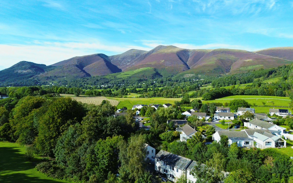 Drone photography of Skiddaw mountain range on a clear sunny day taken from above Fitz Park in Keswick, Lake District